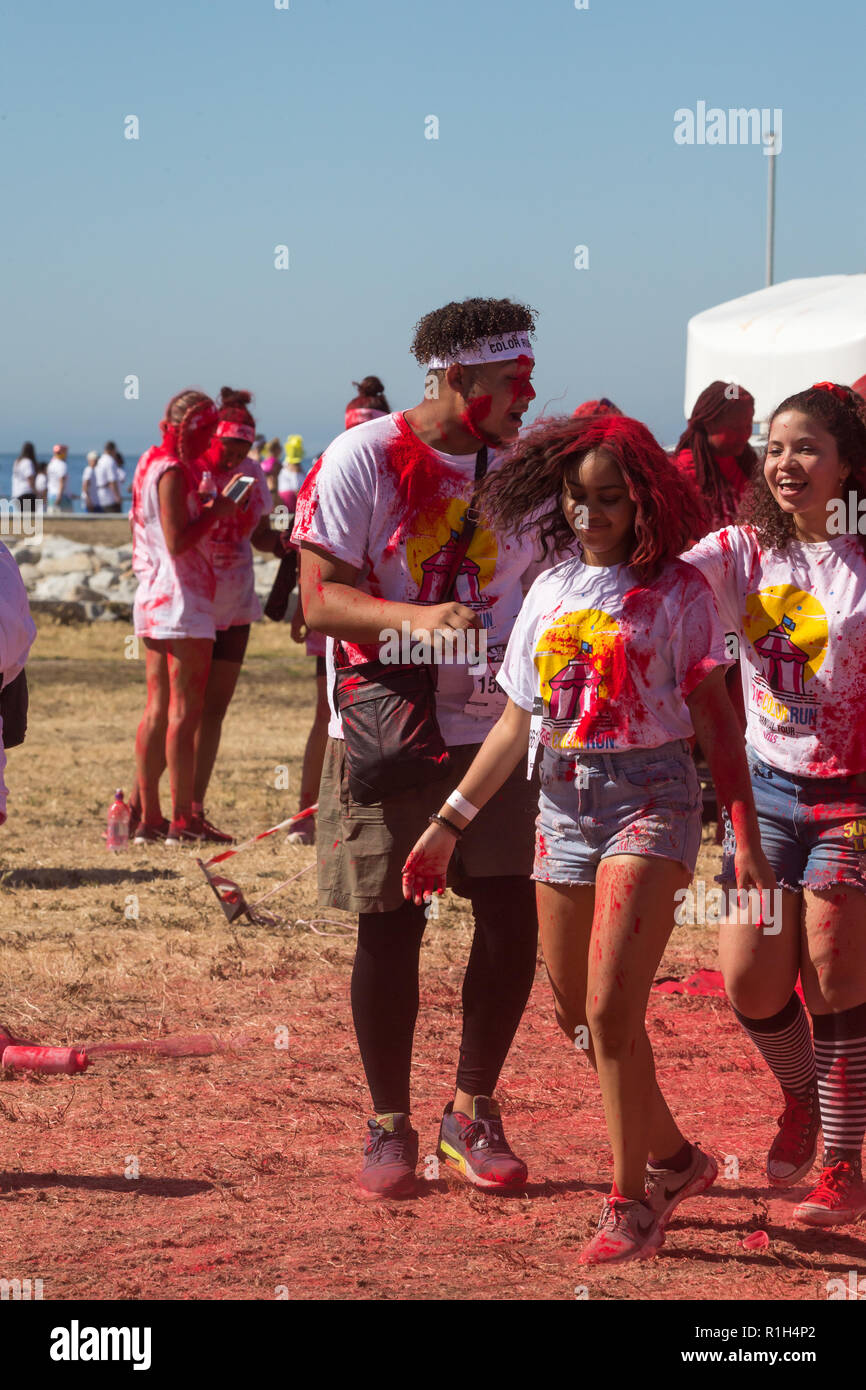 mixed race girl shaking or swinging her hair surrounded by friends at a fun run sports event Cape Town Stock Photo