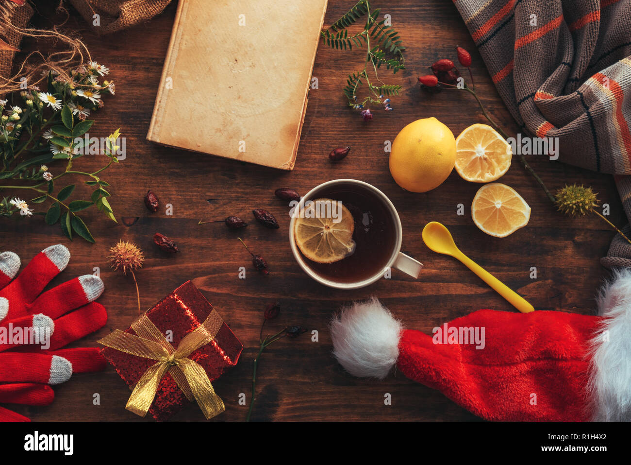 New Year and Christmas flat lay top view with Santa Claus hat, gift box and cup of tea. Happy winter holidays concept. Stock Photo