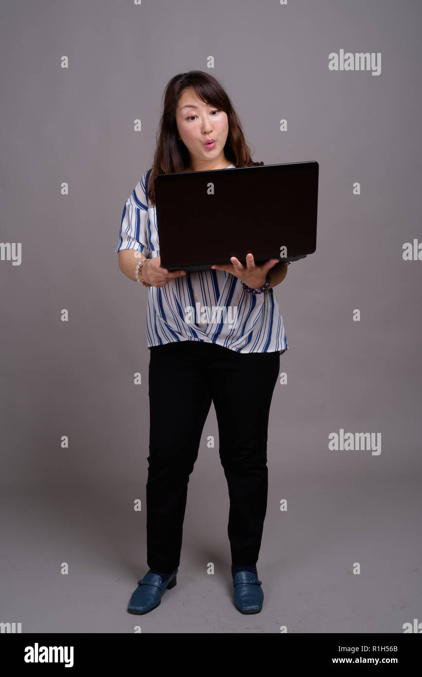 Full length portrait of Japanese businesswoman using laptop computer Stock Photo