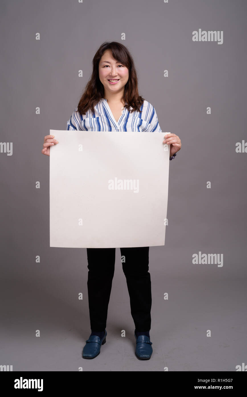 Japanese businesswoman holding white board with copyspace Stock Photo