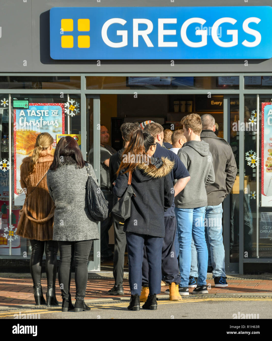 M4 SERVICES, READING, ENGLAND - NOVEMBER 2018: Customers queuing outside the door at the popular branch of Greggs bakery at the service station on the Stock Photo