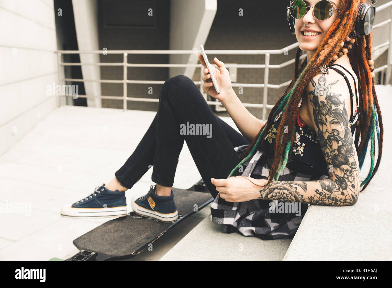 Young Girl With Tattoo And Dreadlocks Listening To Music