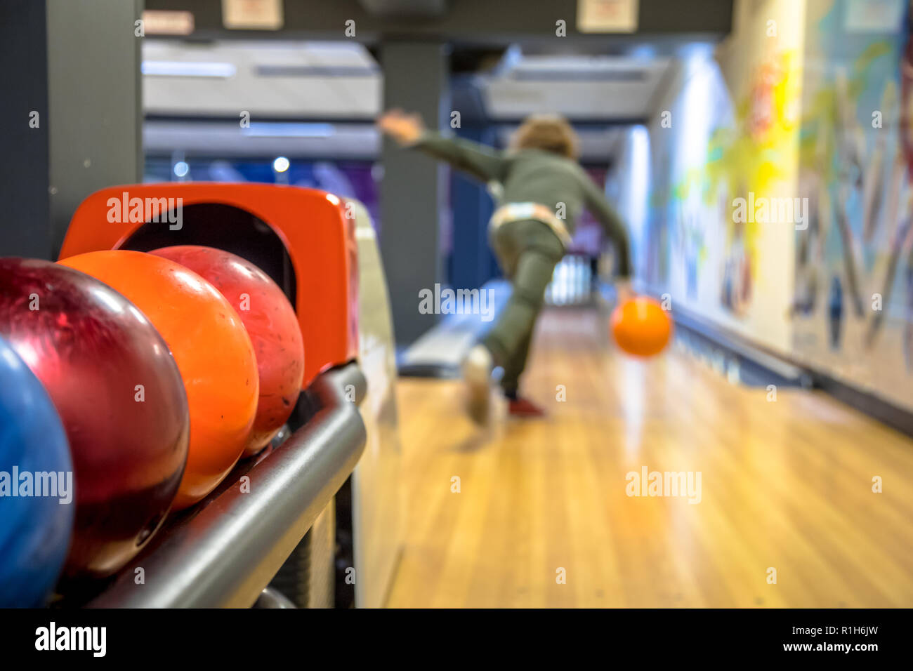 Child throwing bowling ball on indoor bowling alley Stock Photo