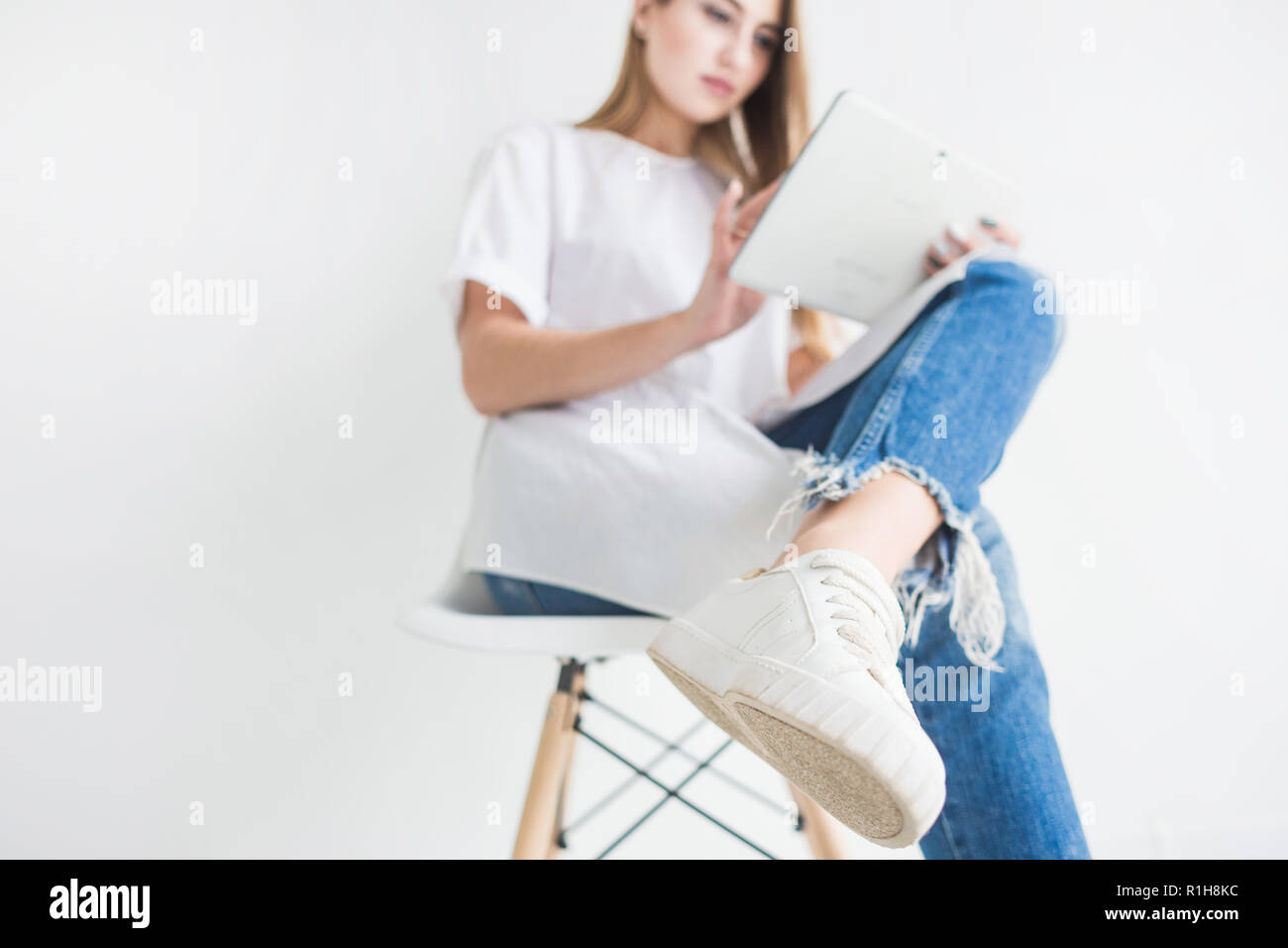 Portrait of a young stylish blonde girl in a white T-shirt and blue ...