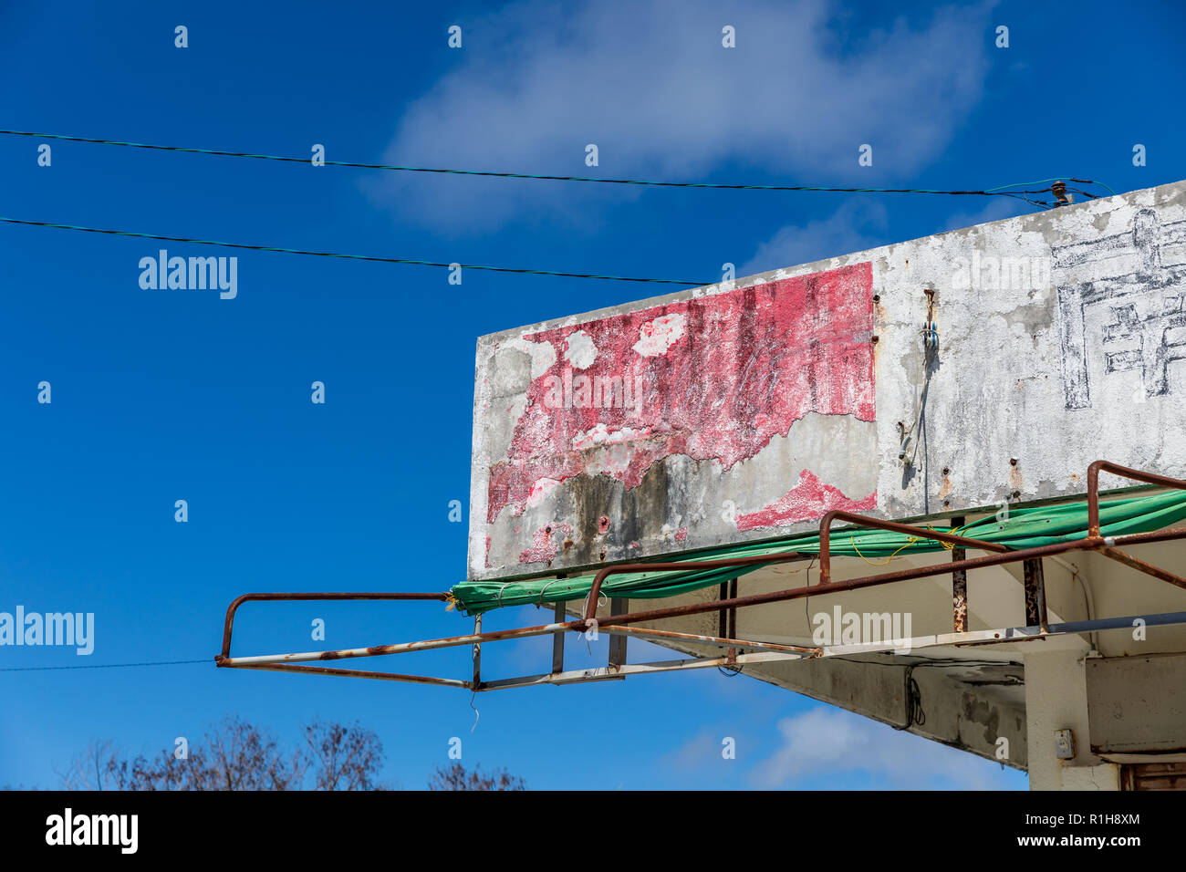 Old, partly disintegrated Coca-Cola sign on concrete roof next to Japanese character 'minami' ('south'); Itoman, Okinawa, Japan Stock Photo
