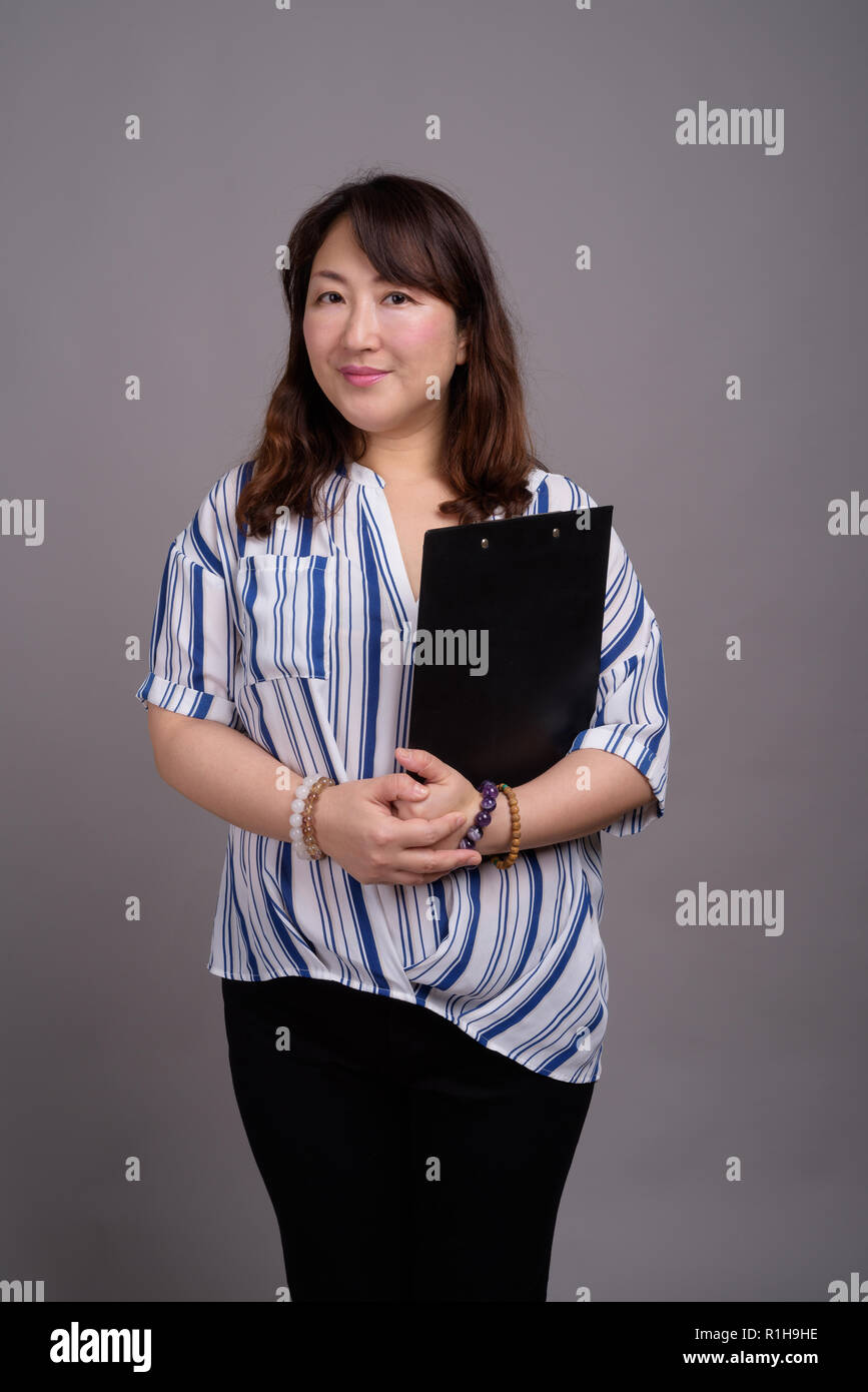 Portrait Of Mature Japanese Businesswoman Holding Clipboard Stock Photo Alamy