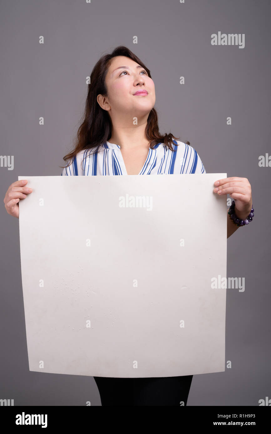 Mature Japanese businesswoman holding empty white copy space Stock Photo