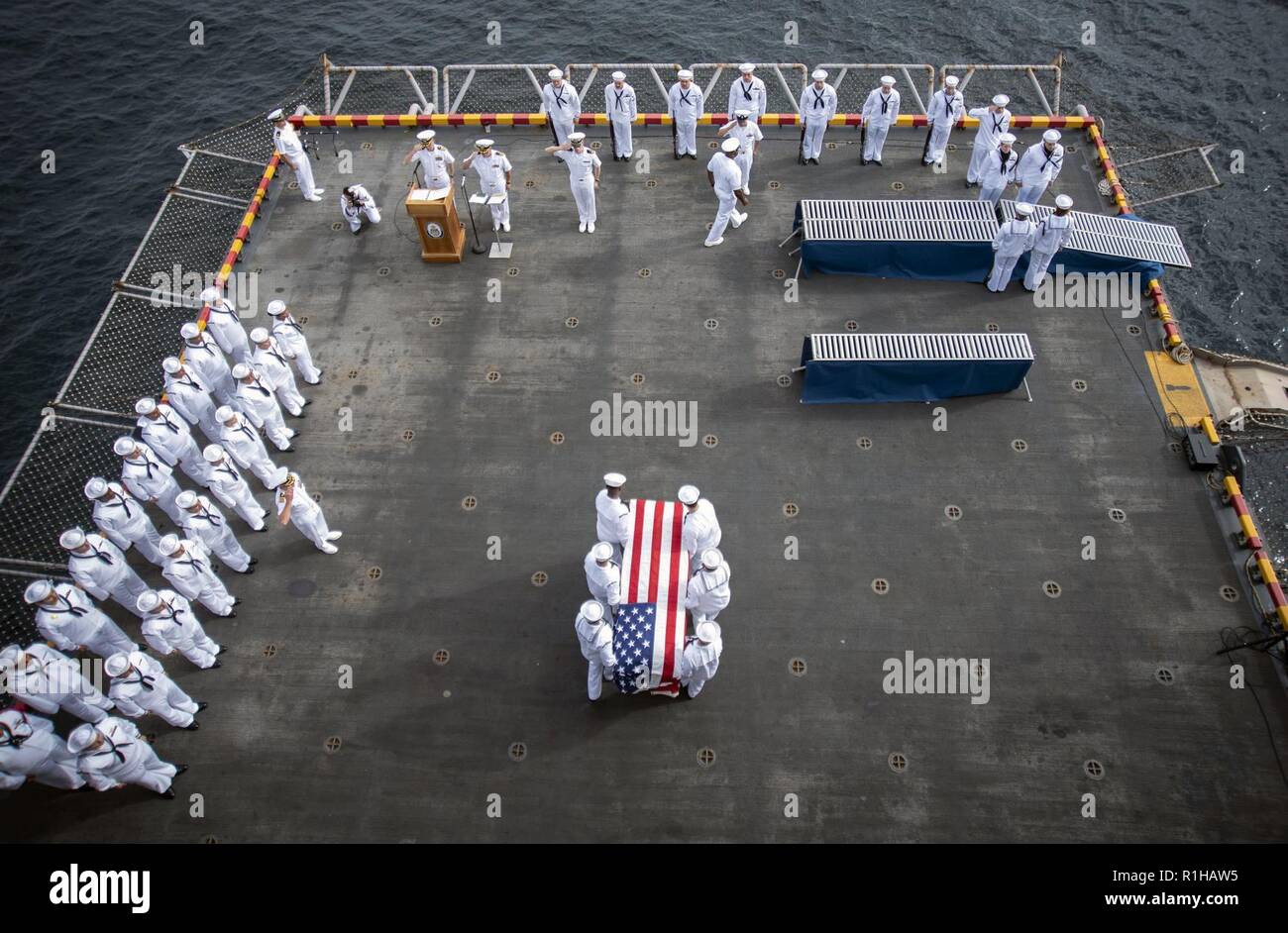 PACIFIC OCEAN (Sept. 19, 2018) Sailors, assigned to the amphibious assault ship USS Bonhomme Richard (LHD 6), serve as pallbearers during a burial at sea ceremony held on the ship’s starboard aircraft elevator. Bonhomme Richard is currently underway in the U.S. 3rd Fleet area of operations. Stock Photo