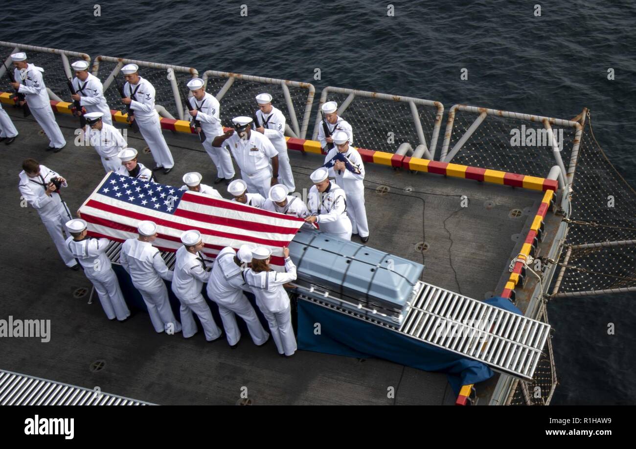 PACIFIC OCEAN (Sept. 19, 2018) Sailors, assigned to the amphibious assault ship USS Bonhomme Richard (LHD 6), conduct a burial at sea during a ceremony held on the ship’s starboard aircraft elevator. Bonhomme Richard is currently underway in the U.S. 3rd Fleet area of operations. Stock Photo