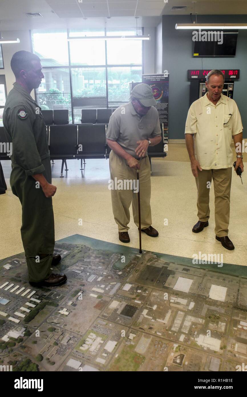 Jeff Telling (right), the Marine Corps Air Station (MCAS) Kaneohe Bay airfield manager, shows a painting of the flightline on the floor of the MCAS terminal to Rep. Steve Cohen (D-TN)(center) during his visit to Marine Corps Base Hawaii (MCBH), Sept. 19, 2018. Rep. Steve Cohen and Rep. Filemon Vela (D-TX) visited MCBH to learn about the installation's support to operational readiness while maintaining awareness of cultural and environmental issues within the training areas, ranges and other aspects of the region. With this engagement, the Representative's will provide Members of Congress with  Stock Photo
