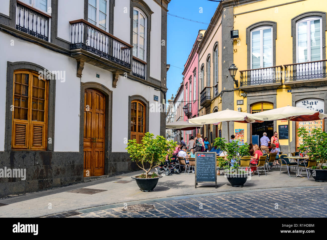 people eating and drinking at a local bar / cafe, clock street, Arucas, Gran Canaria Stock Photo