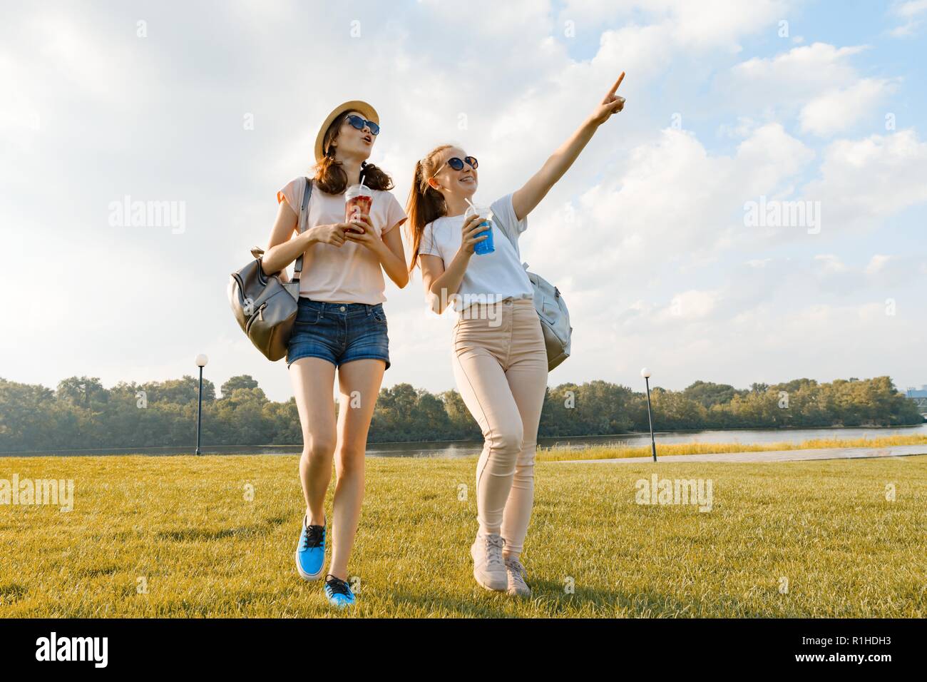 Girl friends are walking in the park in nature. Girls walk along the ...