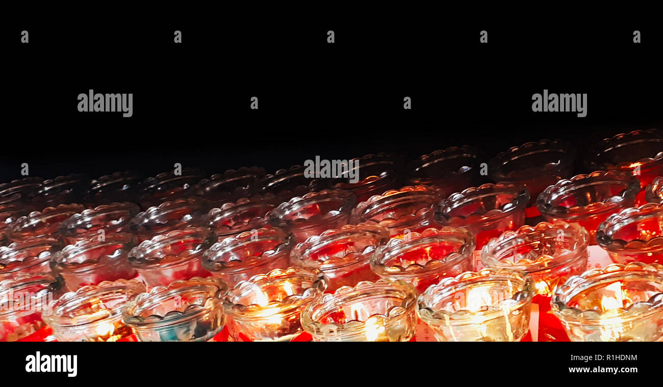 Several burning candles in jars for prayers in kek lok si temple on