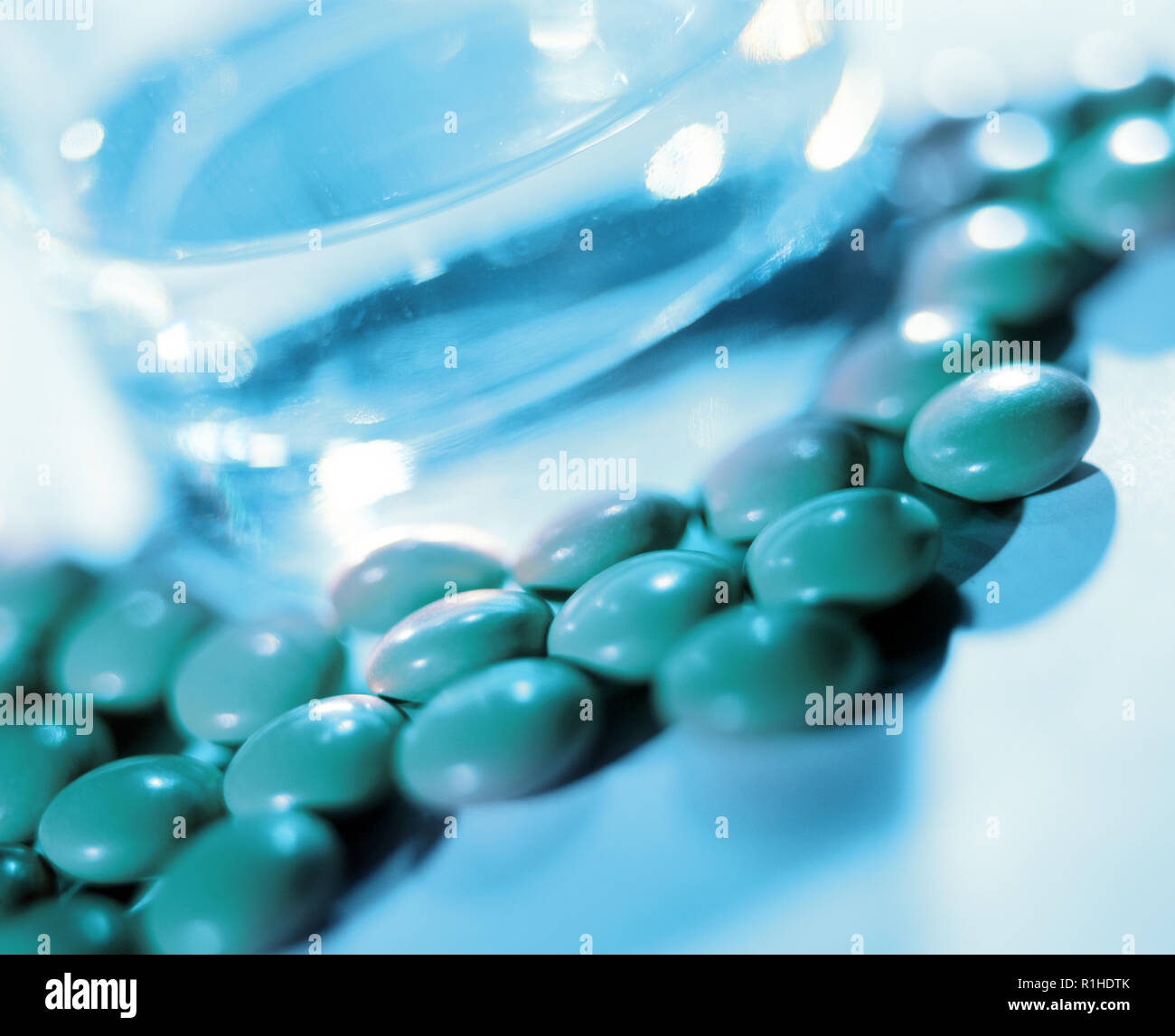 Close-up of pills and glass of water. Stock Photo