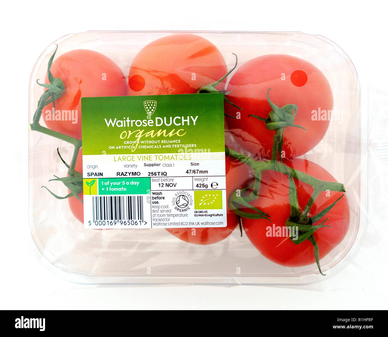 Vine tomatoes in cellophane packaging with information label on white background Stock Photo