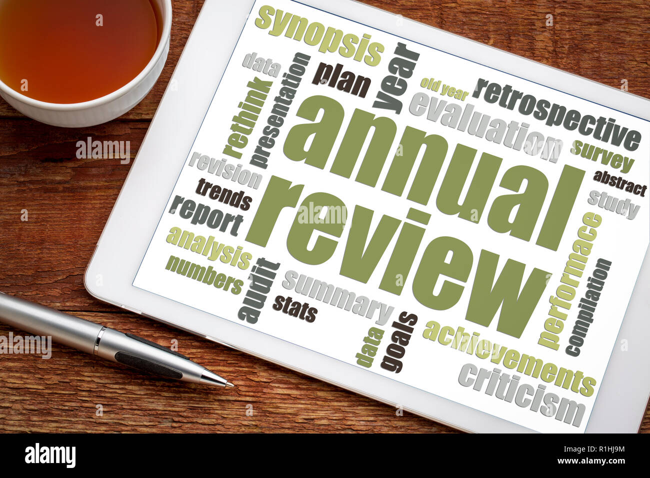 annual review word cloud on a digital  tablet with a cup of tea Stock Photo