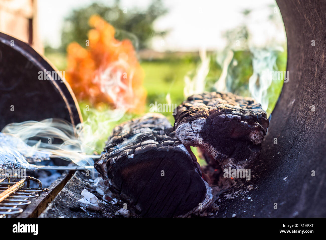 https://c8.alamy.com/comp/R1HRXT/charred-wood-coals-with-smoke-in-bbq-grill-R1HRXT.jpg