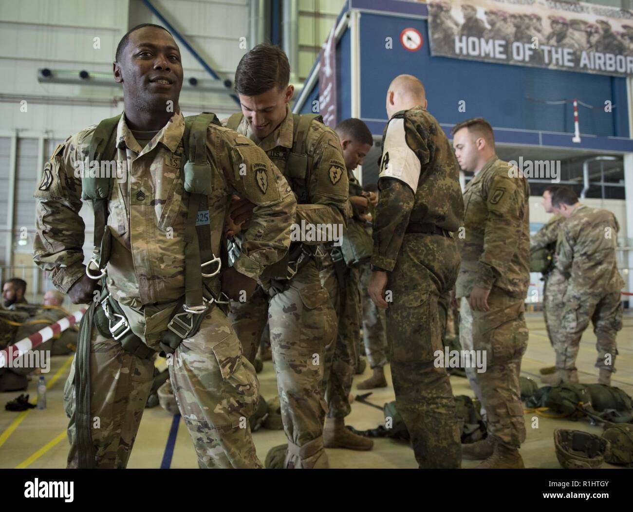 EINDHOVEN, Netherlands  (Sept. 19, 2018) Pvt. Mark Freshour checks Staff Sgt. Maurice Eubanks' gear, both from 1-501st Parachute Infantry Regiment, as they prepare to commemorate the 74th anniversary of Operation Market Garden – the largest airborne operation in history.  This year’s commemoration involves approximately 750 paratroopers from seven different countries participating in a series of airborne operations and events. To this day, generations of Dutch remember the bravery and sacrifice of more than 41,600 troops from the US, UK and Poland who together constituted the Allied Airborne A Stock Photo