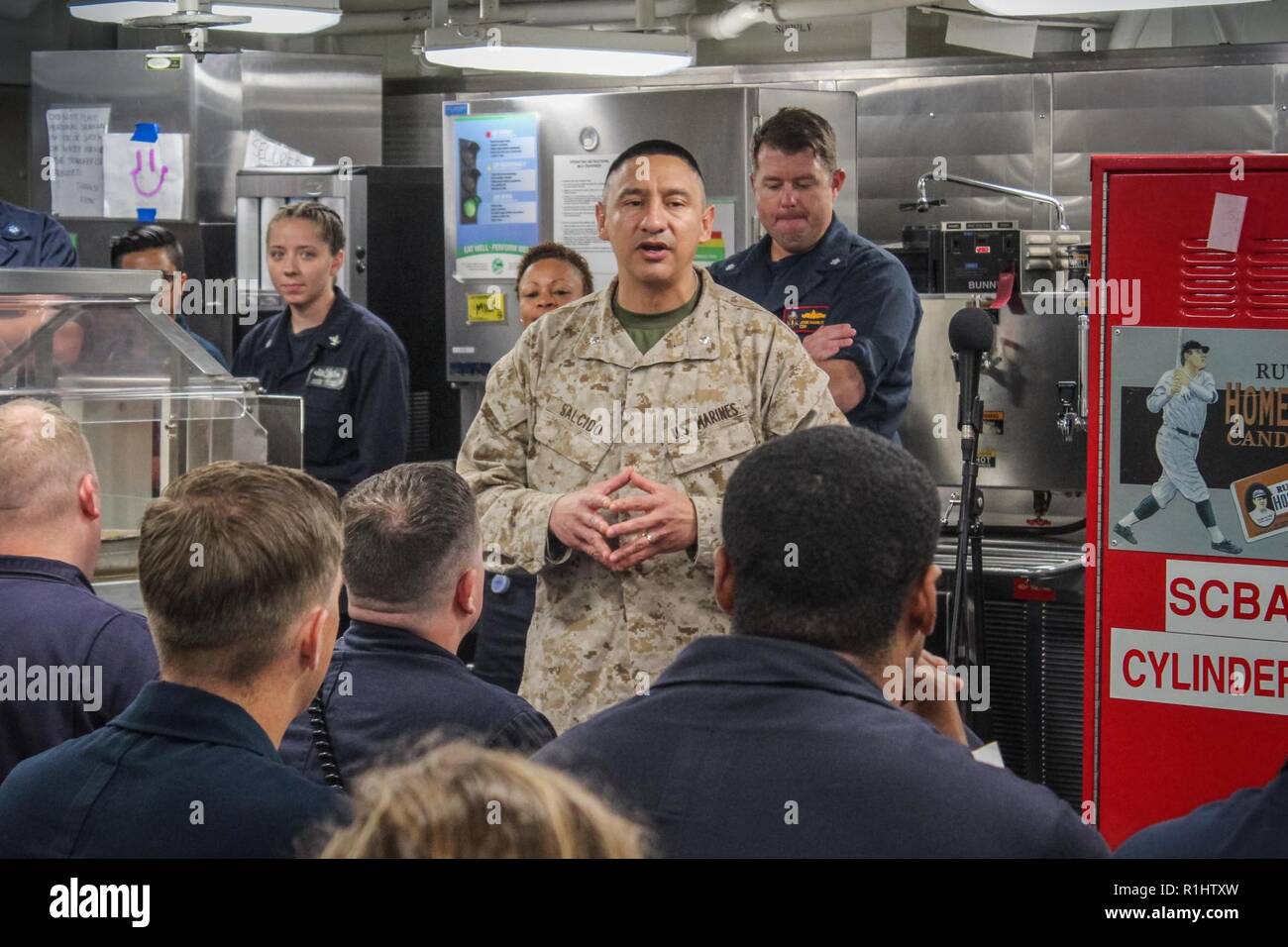 U.S. 5TH FLEET AREA OF OPERATIONS (Sept. 20, 2018) Marine Lt. Col. Rudy Salcido, operations officer for the 13th Marine Expeditionary Unit, speaks to Sailors aboard the guided-missile destroyer USS Jason Dunham (DDG 109). Salcido and Cpl. Jason Dunham were together in Kilo Company, 3rd Battalion, 7th Marines, during the Iraq War when Dunham was killed in action. USS Jason Dunham is deployed to the U.S. 5th Fleet area of operations in support of naval operations to ensure maritime stability and security in the Central Region, connecting the Mediterranean and the Pacific through the western Indi Stock Photo