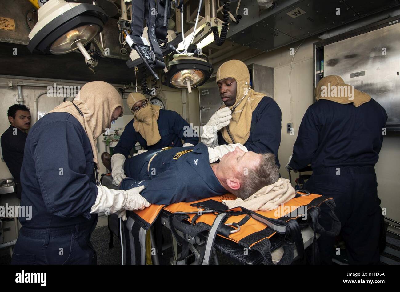 PACIFIC OCEAN (Sept. 21, 2018) Sailors, assigned to the amphibious assault ship USS Bonhomme Richard (LHD 6), simulate providing medical care to Capt. Gregory Thoroman, the ship’s executive officer, in the forward battle dress station during a general quarters drill. Bonhomme Richard is currently underway in the U.S. 3rd Fleet area of operations. Stock Photo