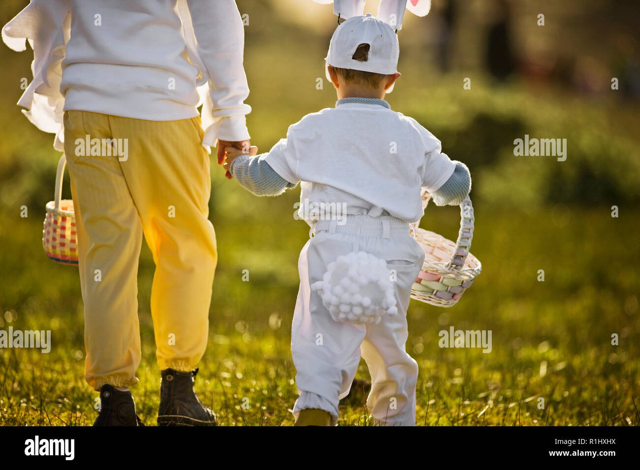 Two brothers in Easter costumes on an Easter egg hunt Stock Photo