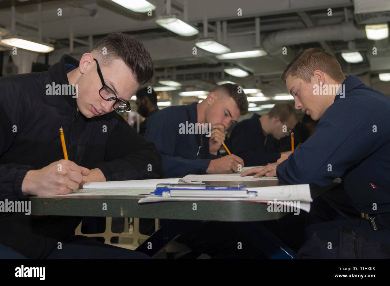 SAN DIEGO (Sept. 20, 2018) Sailors, assigned to the amphibious assault ship USS Bonhomme Richard (LHD6), take the Navywide E-4 advancement exam on the ship’s mess deck. Bonhomme Richard is currently underway in the U.S. 3rd Fleet area of operations. Stock Photo