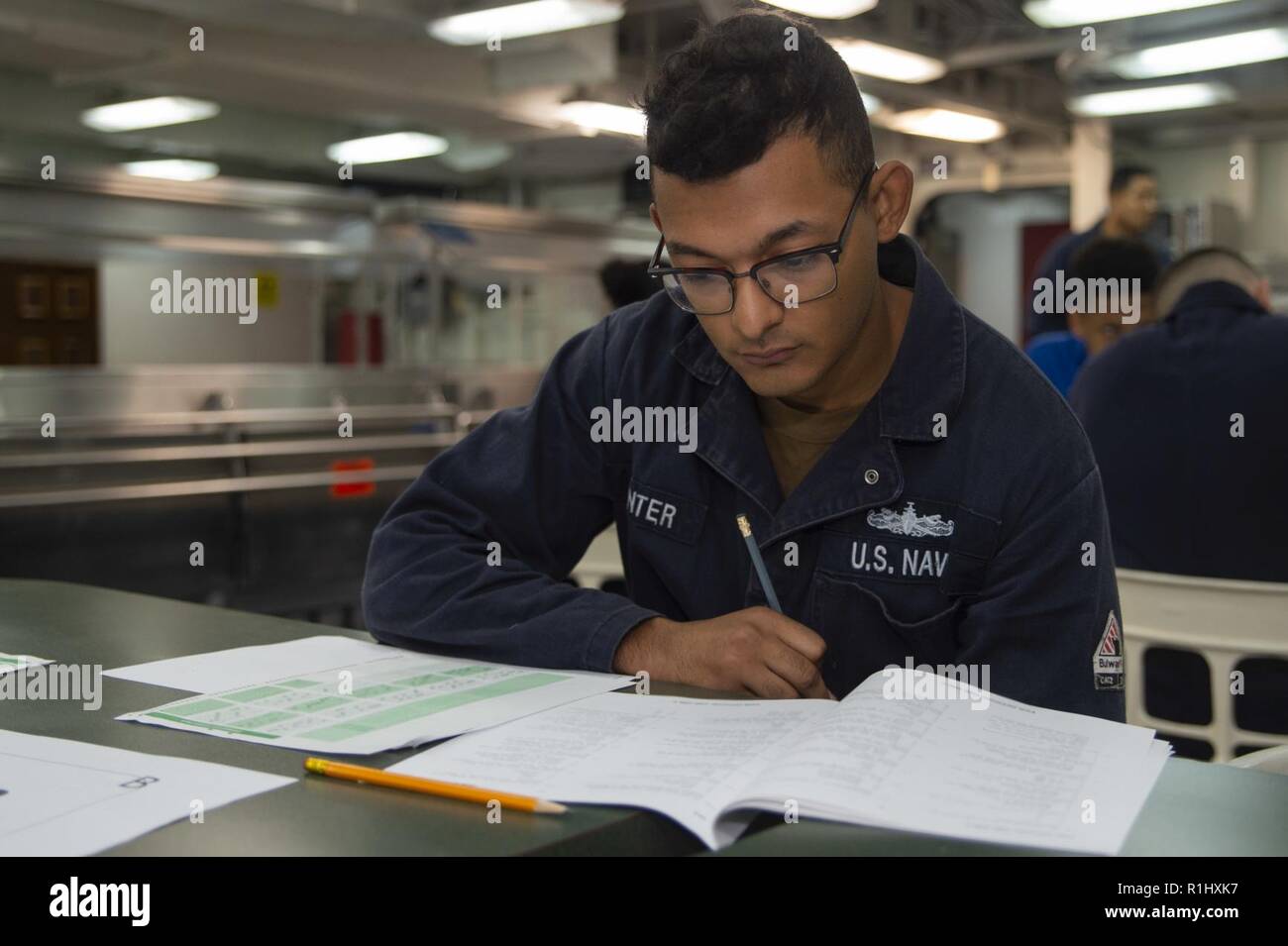 SAN DIEGO(Sept. 20, 2018) Hull Maintenance Technician Fireman Brandon Gunter, from Atlanta, takes the Navywide E-4 advancement exam on the mess deck of the amphibious assault ship USS Bonhomme Richard (LHD 6). Bonhomme Richard is currently underway in the U.S. 3rd Fleet area of operations. Stock Photo