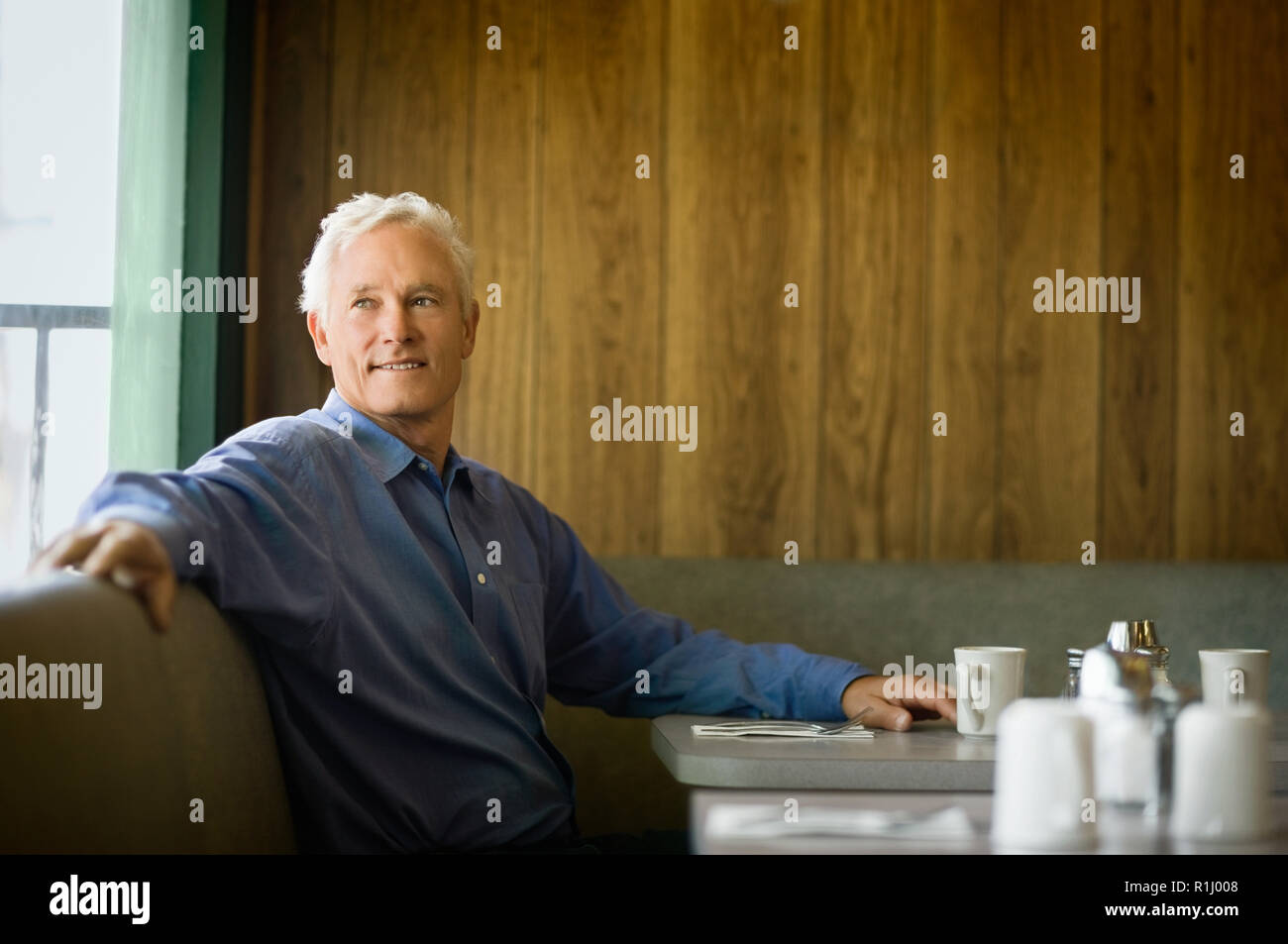 Mature man sitting in diner booth Stock Photo