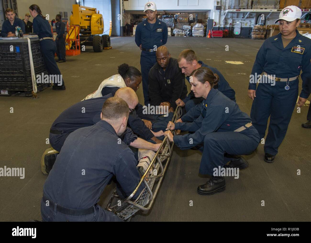 PACIFIC OCEAN (Sept. 21, 2018) Sailors, assigned to the amphibious assault ship USS Bonhomme Richard (LHD 6), place a simulated casualty onto a stretcher during a mass casualty drill in the ship’s hangar bay. Bonhomme Richard is currently underway in the U.S. 3rd Fleet area of operations. Stock Photo