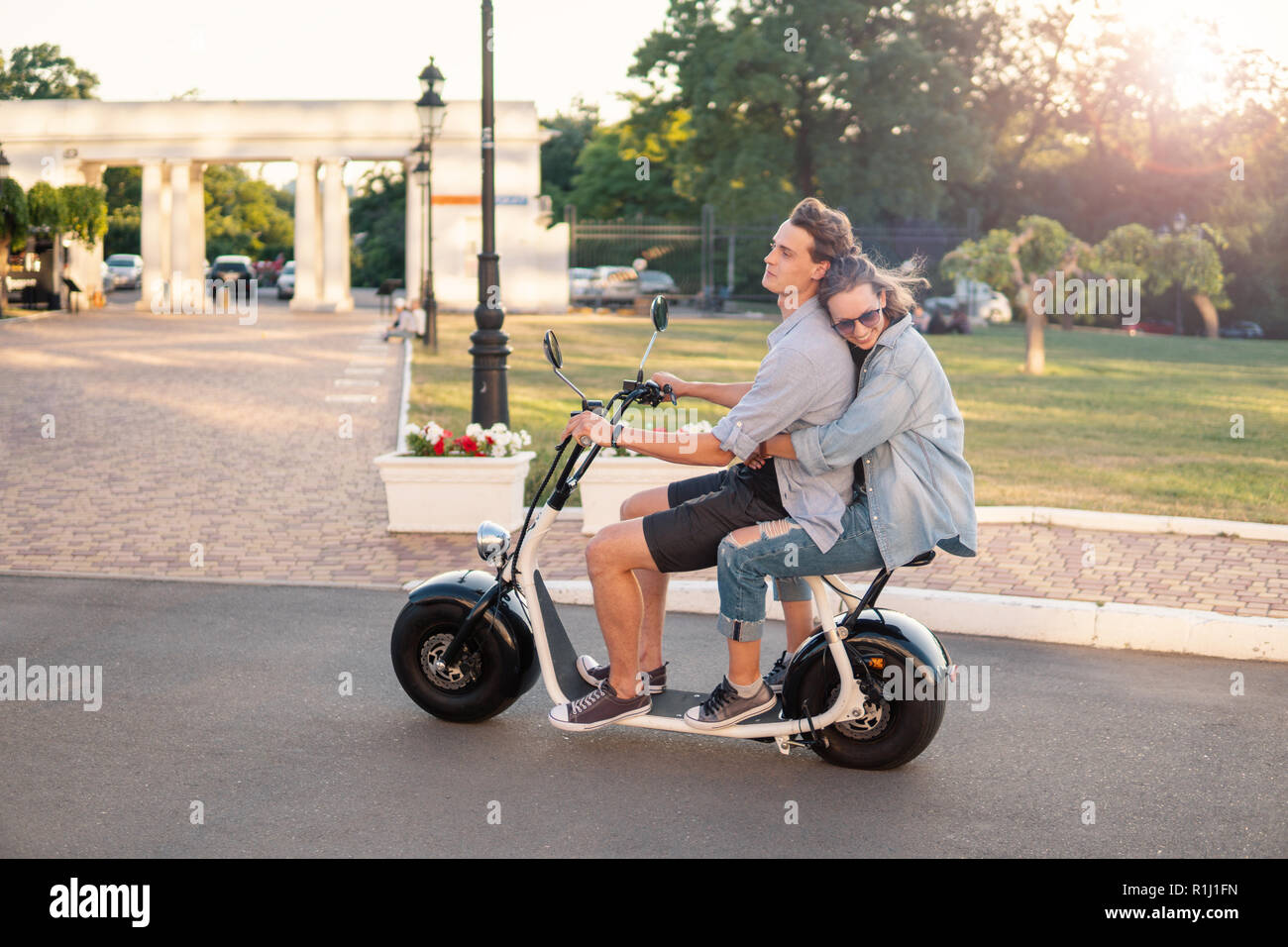 Lovely young happy couple driving electric bike Stock Photo