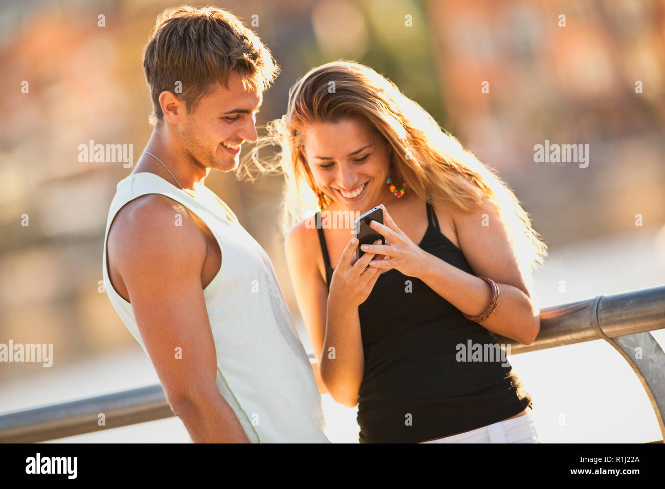 Young couple looking at something on a cell phone. Stock Photo