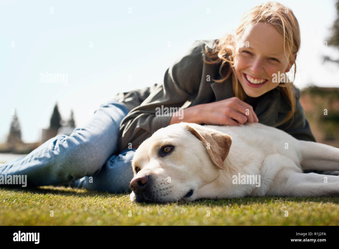 Smiling teenage girl lying on her Labrador dog Stock Photo - Alamy