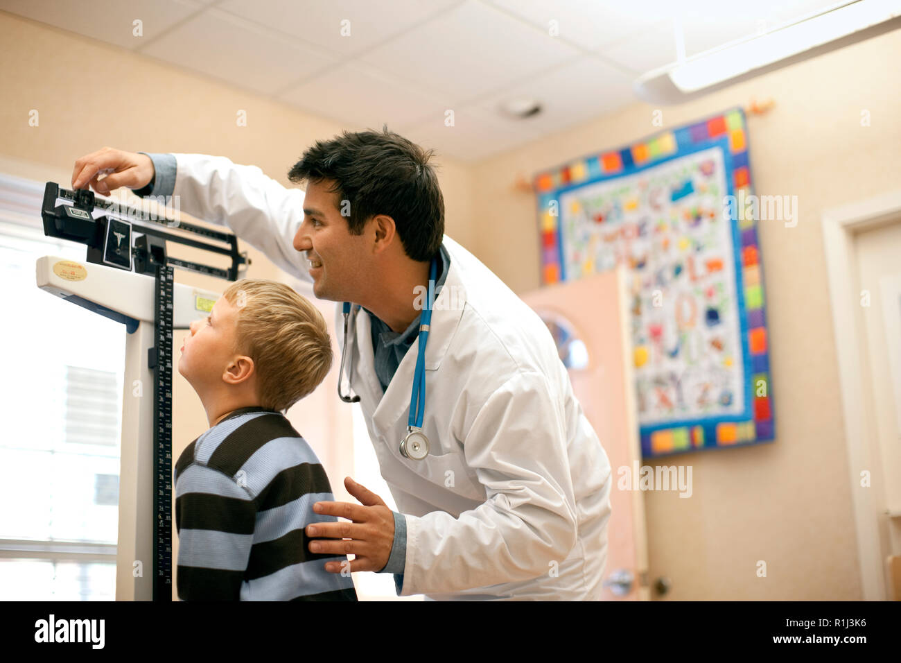Doctor measuring young patient's weight on the medical weight scales