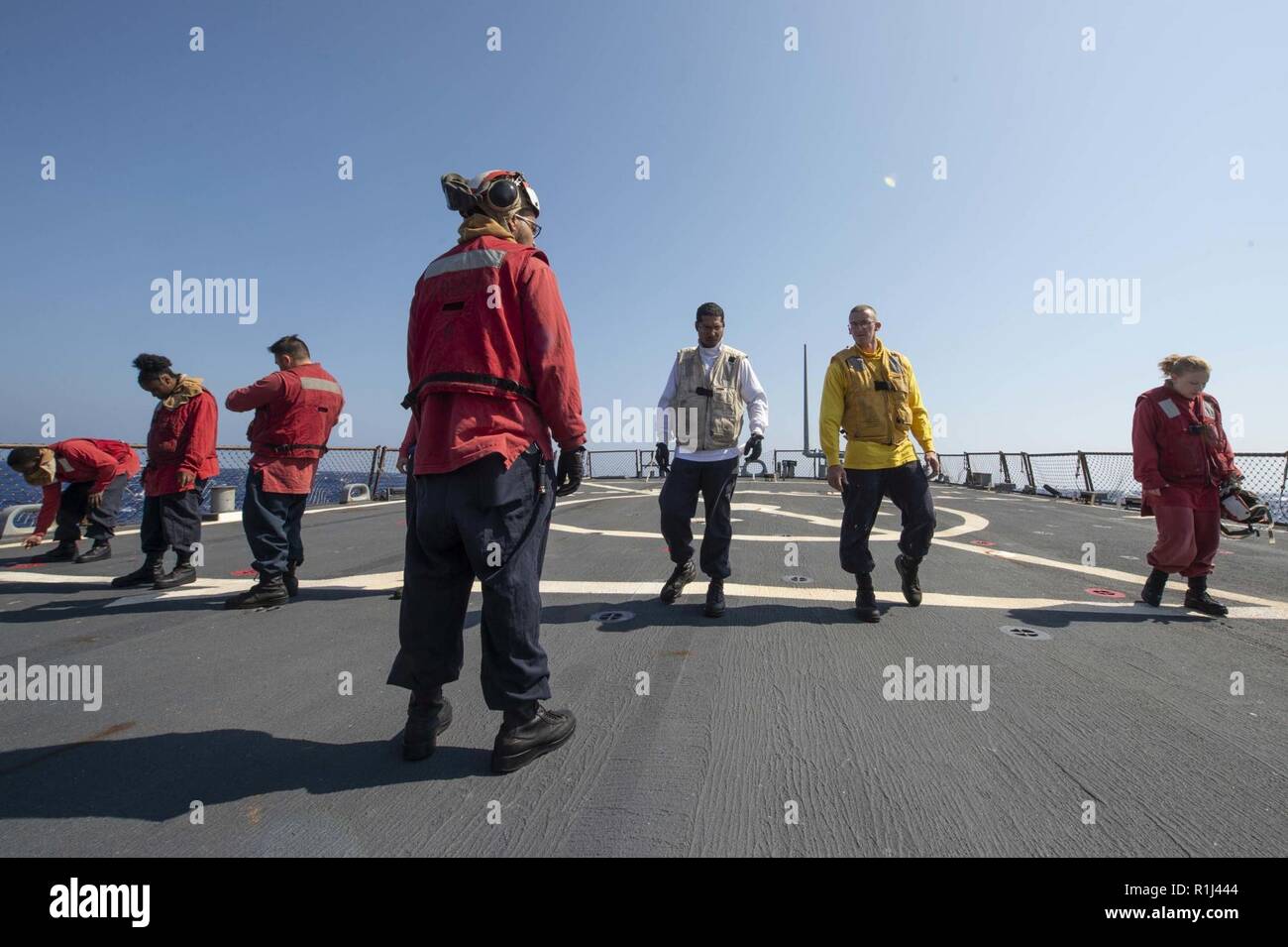 MEDITERRANEAN SEA (Sept. 26, 2018) Sailors look for foreign object debris on the flight deck before the start of flight operations aboard the Arleigh Burke-class guided-missile destroyer USS Arleigh Burke (DDG 51) in the Mediterranean Sea Sept. 26, 2018. Arleigh Burke, homeported at Naval Station Norfolk, is conducting naval operations in the U.S. 6th Fleet area of operations in support of U.S. national security interests in Europe and Africa. Stock Photo