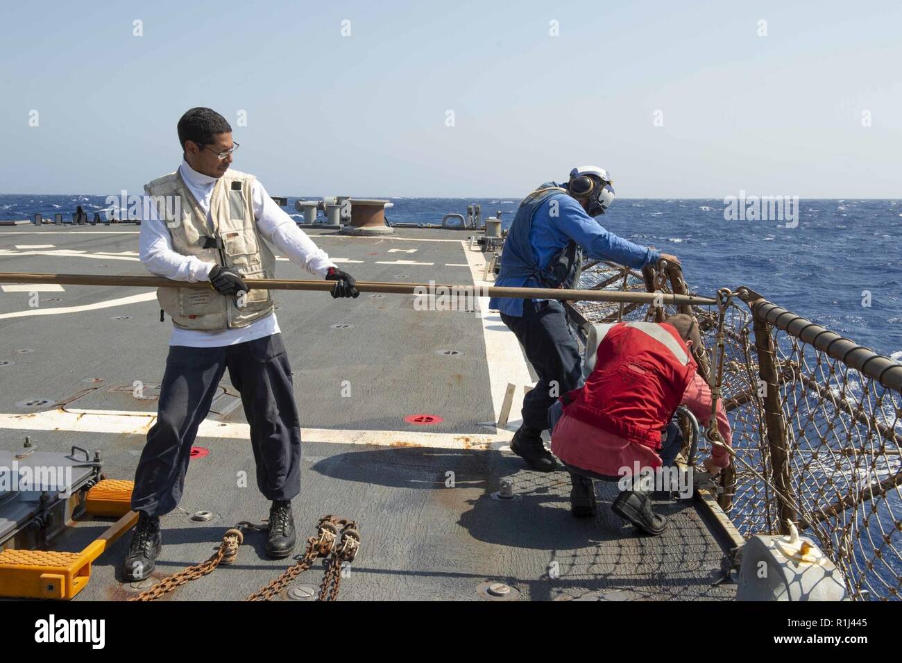 MEDITERRANEAN SEA (Sept. 26, 2018) Sailors lower safety deck nets on the flight deck before the start of flight operations aboard the Arleigh Burke-class guided-missile destroyer USS Arleigh Burke (DDG 51) in the Mediterranean Sea Sept. 26, 2018. Arleigh Burke, homeported at Naval Station Norfolk, is conducting naval operations in the U.S. 6th Fleet area of operations in support of U.S. national security interests in Europe and Africa. Stock Photo