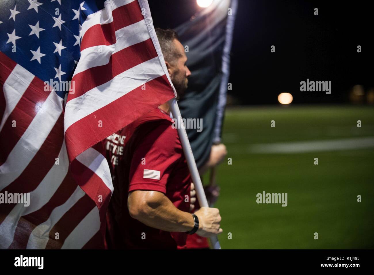 Members of Team Red, White and Blue carry the American Flag alongside