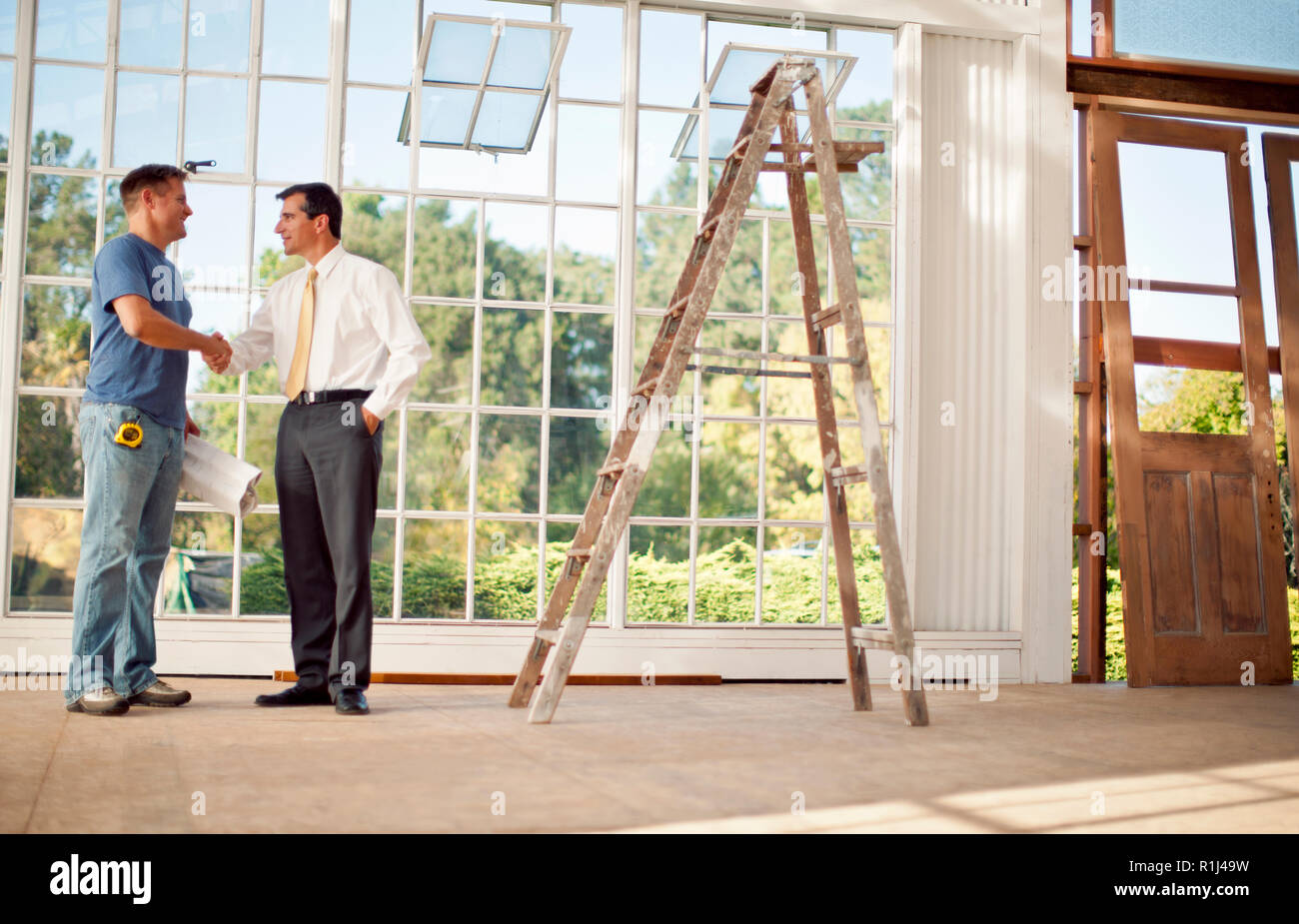 Mid adult builder working on blue prints. Stock Photo
