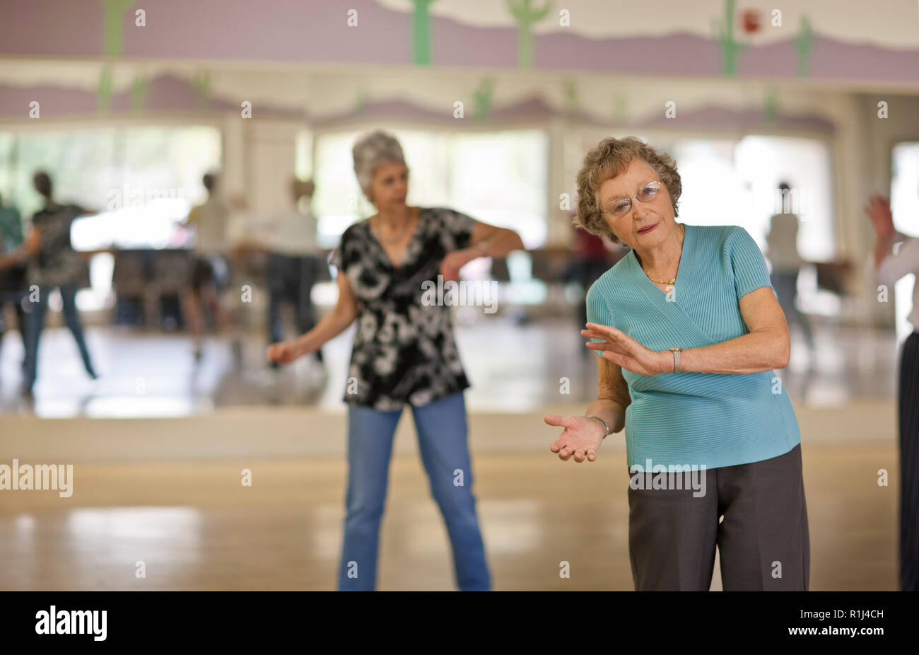 Portrait of a smiling senior woman having fun at an exercise class ...