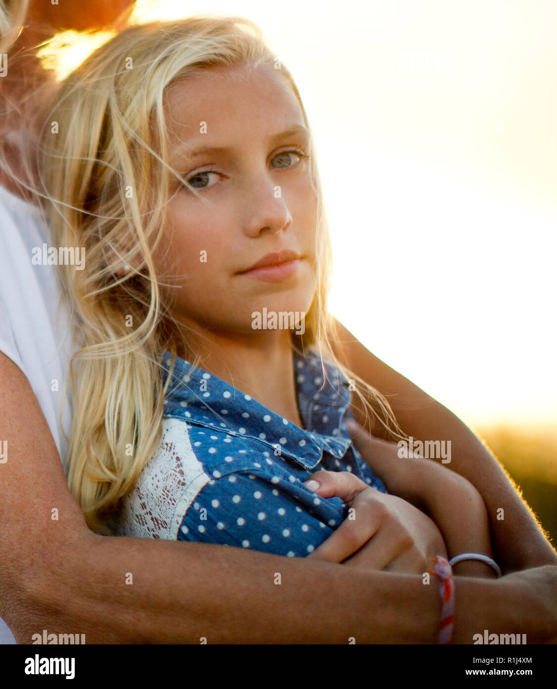 Portrait of a teenage girl leaning against her mother. Stock Photo