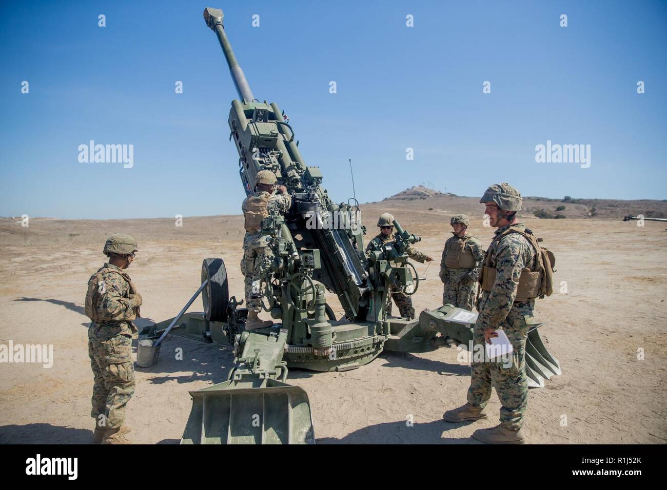 U.S. Marines with India Battery, 3rd Battalion, 11th Marine Regiment, 1st Marine Division, are being evaluated on proper maintenance of an M777 155mm Howitzer cannon during a Cannon Section Chief Course at Artillery Fire Area 18, Marine Corps Base Camp Pendleton, California, Sept. 27, 2018. The section chief is responsible for the safety of each Marine operating the Howitzer along with the training and proficiency of the section. Stock Photo