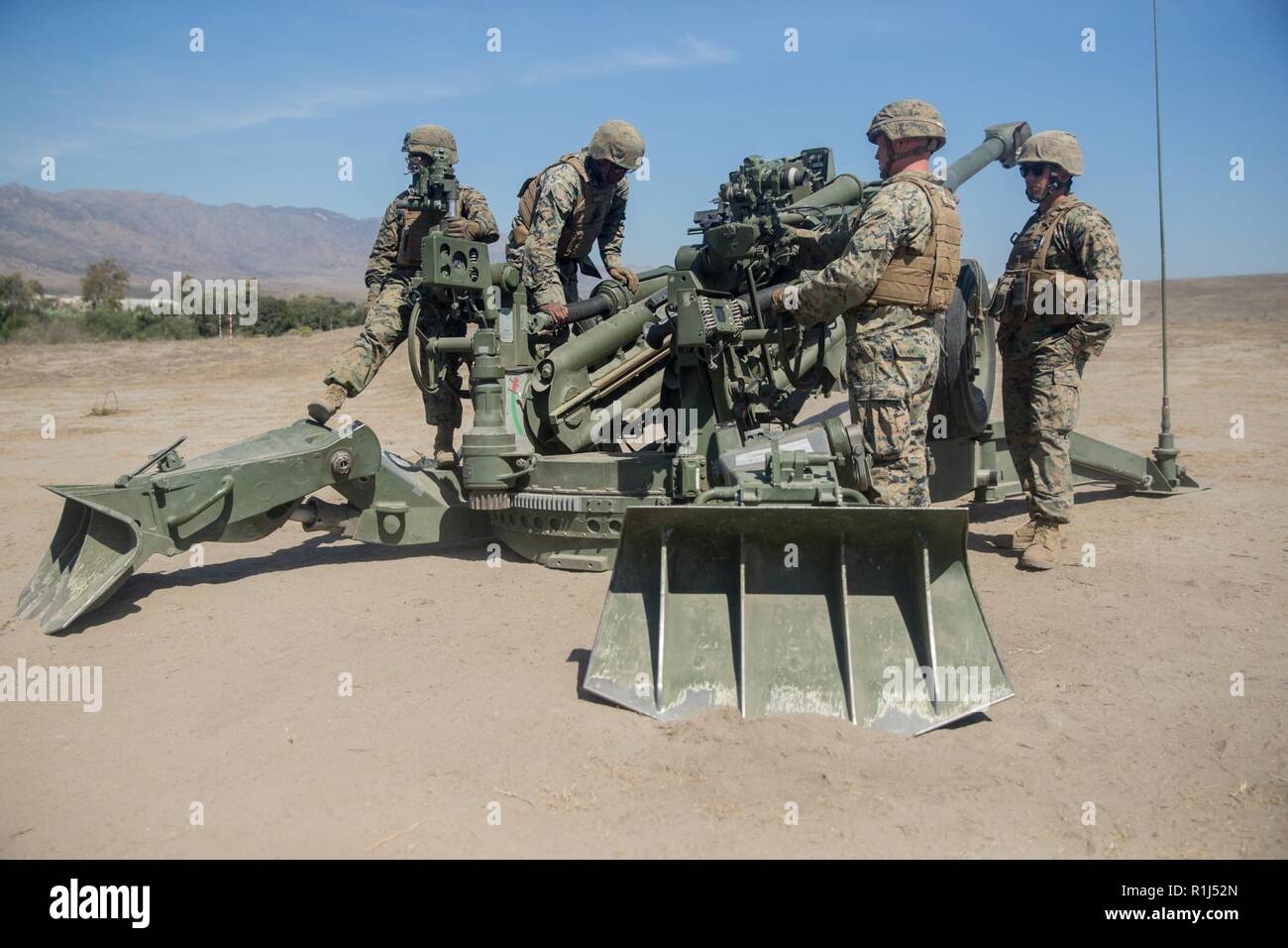 U.S. Marines with India Battery, 3rd Battalion, 11th Marine Regiment, 1st Marine Division, conducts a practical application assessment on an M777 155mm Howitzer cannon during a Cannon Section Chief Course at Artillery Fire Area 18, Marine Corps Base Camp Pendleton, California, Sept. 27, 2018. The section chief is responsible for the safety of each Marine operating the Howitzer along with the training and proficiency of the section. Stock Photo