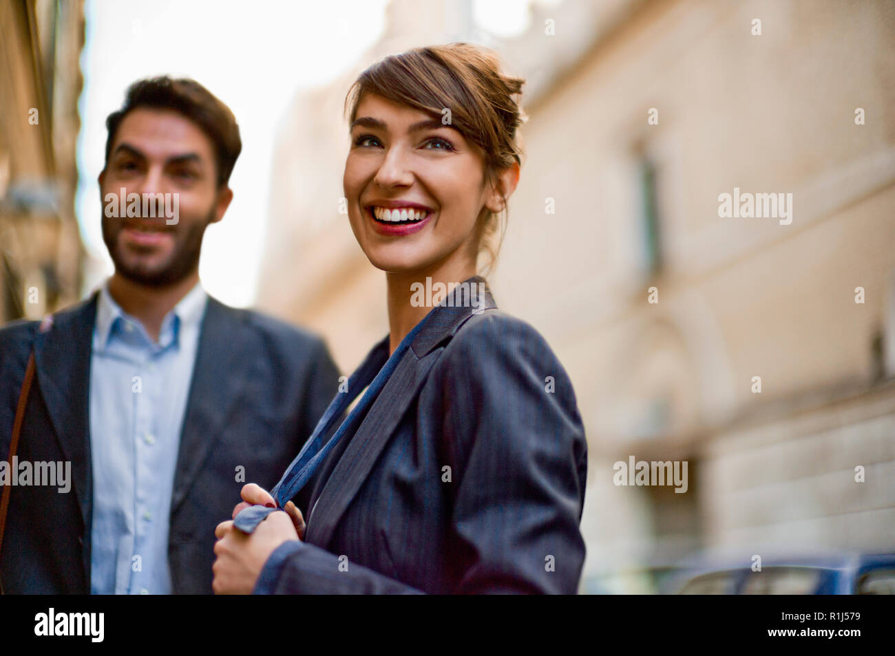 Two young colleagues head out on a date in the city at lunchtime. Stock Photo