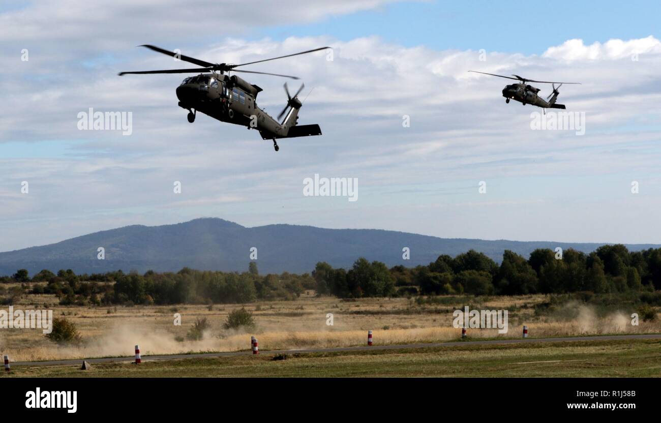 Two UH-60 Black Hawk helicopters drop off distinguished visitors for a live fire exercise as a part of Operation Slovak Shield 2018 at the Lest Military Training Area in Lest, Slovakia, Sept. 27.    The exercise features U.S. Soldiers from 1st Squadron, 7th Cavalry Regiment, 1st Armored Brigade Combat Team, 1st Cavalry Division from Fort Hood, Texas, integrated with Slovakian Soldiers to demonstrate their combined forces capabilities.     1-7 Cavalry Regiment and the Slovakian Army demonstrated live mortar firing, live-fire from military vehicles, dismounted-Soldier live fire, and simulated ca Stock Photo