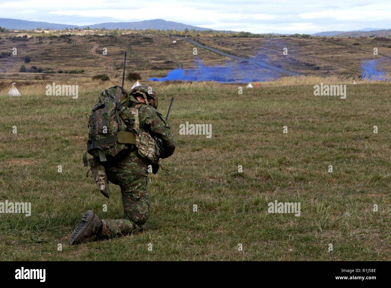 A Slovakian Soldier kneels and communicates with his team through a radio during a live-fire exercise for Operation Slovak Shield 2018 at the Lest Military Training Area in Lest, Slovakia, Sept. 27.    The exercise features U.S. Soldiers from 1st Squadron, 7th Cavalry Regiment, 1st Armored Brigade Combat Team, 1st Cavalry Division from Fort Hood, Texas, integrated with Slovakian Soldiers to demonstrate their combined forces capabilities.     1-7 Cavalry Regiment and the Slovakian Army demonstrated live mortar firing, live-fire from military vehicles, dismounted-Soldier live fire, and simulated Stock Photo