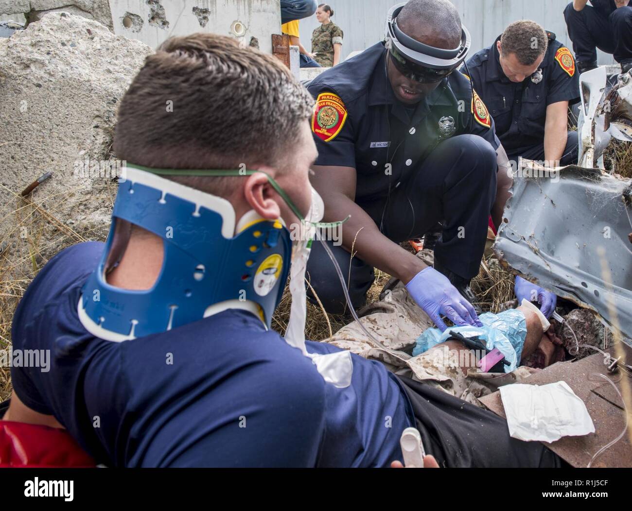 SAN FRANCISCO (Oct. 3, 2018) Damon Victor (right), a paramedic assigned to the San Francisco Fire Department, holds pressure on the amputation site of a simulated patient’s leg while using augmented reality glasses to update a doctor in San Diego about the mock patient’s status as part of a tele-medical training exercise during San Francisco Fleet Week (SFFW) 2018. SFFW is an opportunity for the American public to meet their Navy, Marine Corps and Coast Guard teams and experience America's sea services. During fleet week, service members participate in various community service events, showcas Stock Photo