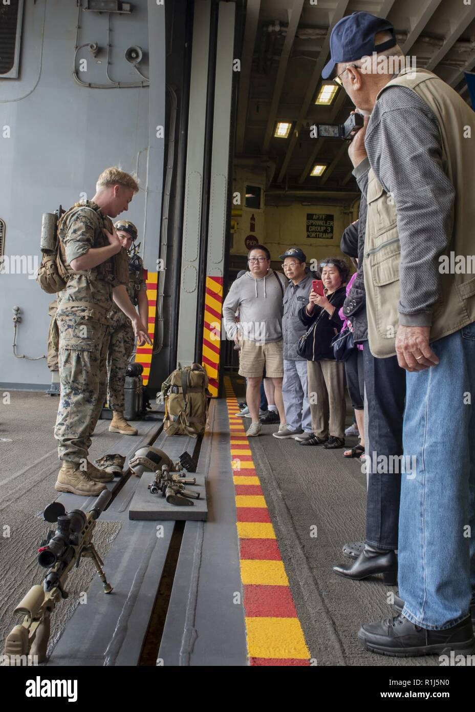 SAN FRANCISCO (Oct. 4, 2018) Sgt. Jack Seward, from Huntington Beach, Calif., assigned to the 3rd Battalion, 11th Marine Division, displays Marine equipment to visitors during a general public ship tour of the amphibious assault ship USS Bonhomme Richard (LHD 6) during San Francisco Fleet Week 2018. San Francisco Fleet Week is an opportunity for the American public to meet their Navy, Marine Corps and Coast Guard teams and experience America’s sea services. During fleet week, service members participate in various community service events, showcase capabilities and equipment to the community,  Stock Photo