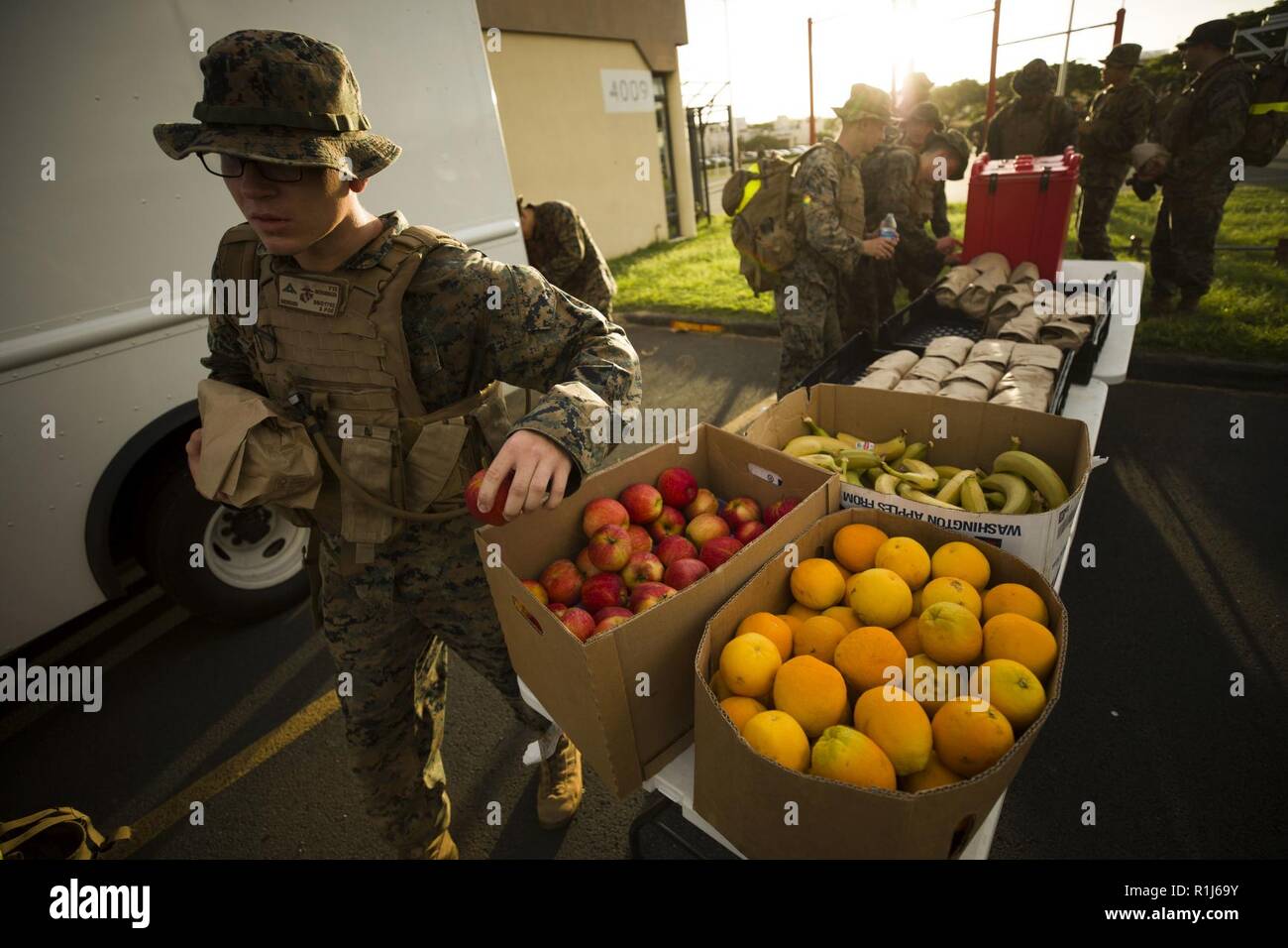 U.S. Marines assigned to Headquarters Battalion, Marine Corps Base Hawaii (MCBH), grab fruit after conducting a battalion hike, MCBH, Oct. 5, 2018. The purpose of the hike was to increase physical and mental stamina, build espirit de corps, and to bolster combat readiness. Stock Photo