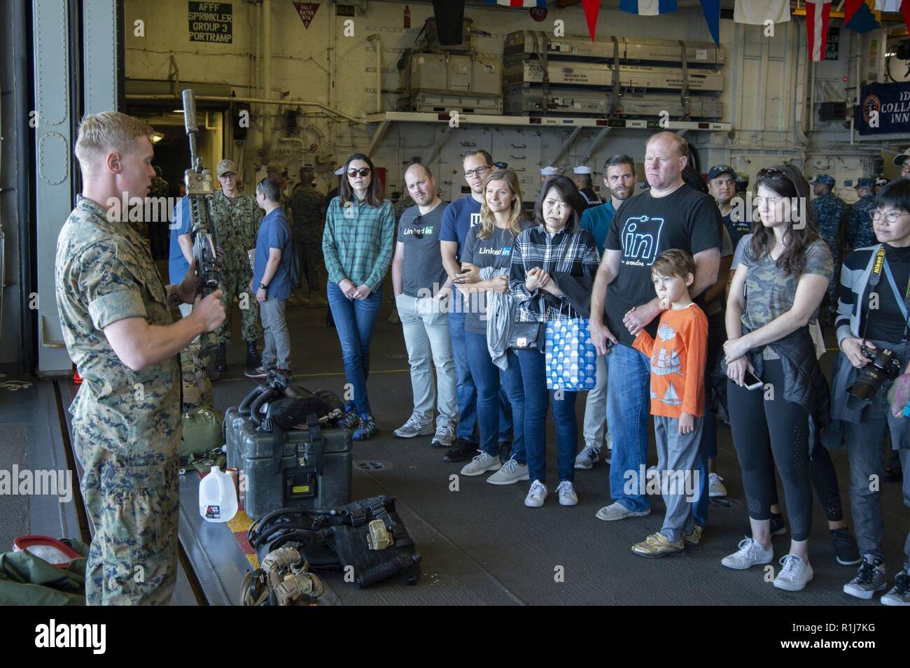 SAN FRANCISCO (Oct. 6, 2018) Cpl. Ryan Schutz, from Kalamazoo, Mich., assigned to the 3rd Light Armored Reconnaissance Battalion (LAR), describes Marine equipment capabilities to visitors during a general public ship tour as part of San Francisco Fleet Week 2018. San Francisco Fleet Week is an opportunity for the American public to meet their Navy, Marine Corps and Coast Guard teams and experience America’s sea services. During fleet week, service members participate in various community service events, showcase capabilities and equipment to the community, and enjoy the hospitality of San Fran Stock Photo
