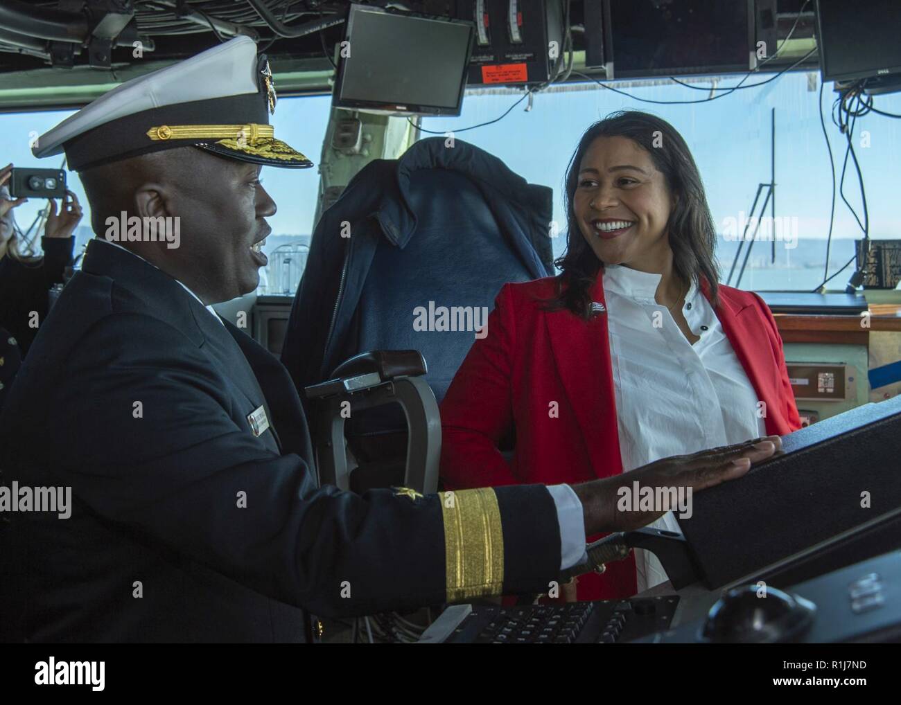 SAN FRANCISCO (Oct. 7, 2018) Rear Adm. Cedric Pringle, left, commander, Expeditionary Strike Group (ESG) 3, describes bridge operations to London Breed, mayor of San Francisco, during a tour of the amphibious assault ship USS Bonhomme Richard (LHD 6) as part of San Francisco Fleet Week 2018. San Francisco Fleet Week is an opportunity for the American public to meet their Navy, Marine Corps and Coast Guard teams and experience America’s sea services. During fleet week, service members participate in various community service events, showcase capabilities and equipment to the community, and enjo Stock Photo