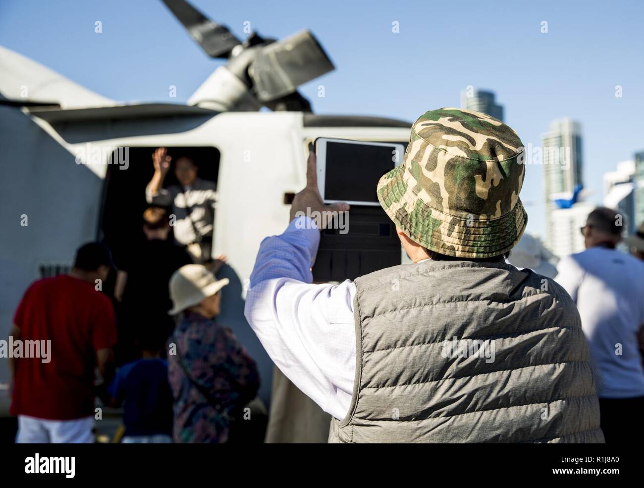 Residents of San Francisco climb inside an MV-22 Osprey during a ship tour of USS Bonhomme Richard (LHD-6) while docked at Pier 30/32 in San Francisco, October 8, 2018. San Francisco Fleet Week is an opportunity for the American public to meet their Navy, Marine Corps and Coast Guard teams and experience America’s sea services. During fleet week, service members participate in various community service events and showcase capabilities and equipment to the community. Stock Photo